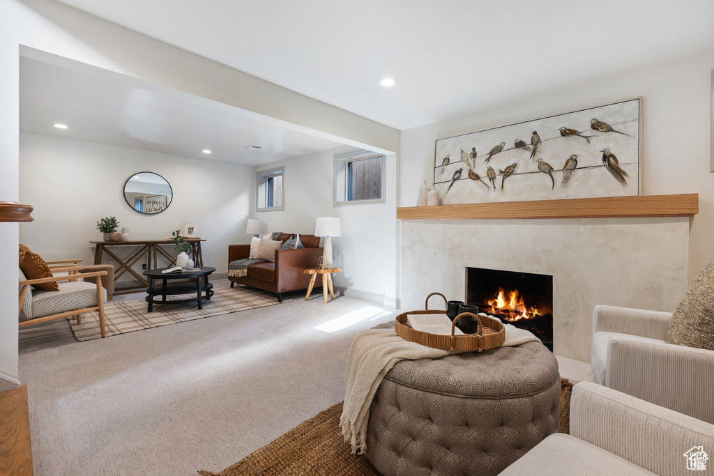 Living area with a fireplace, recessed lighting, and carpet