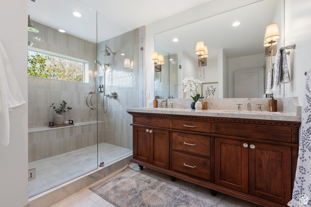 Bathroom featuring walk in shower, double vanity, and recessed lighting