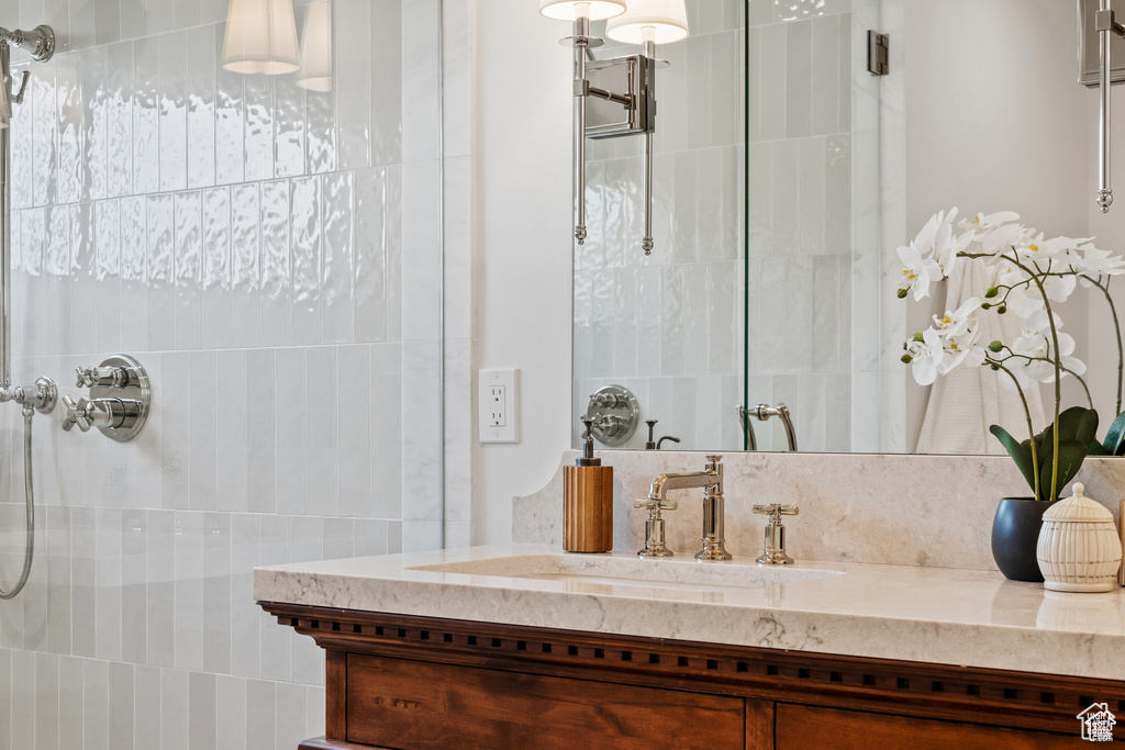 Bathroom featuring a tile shower and vanity