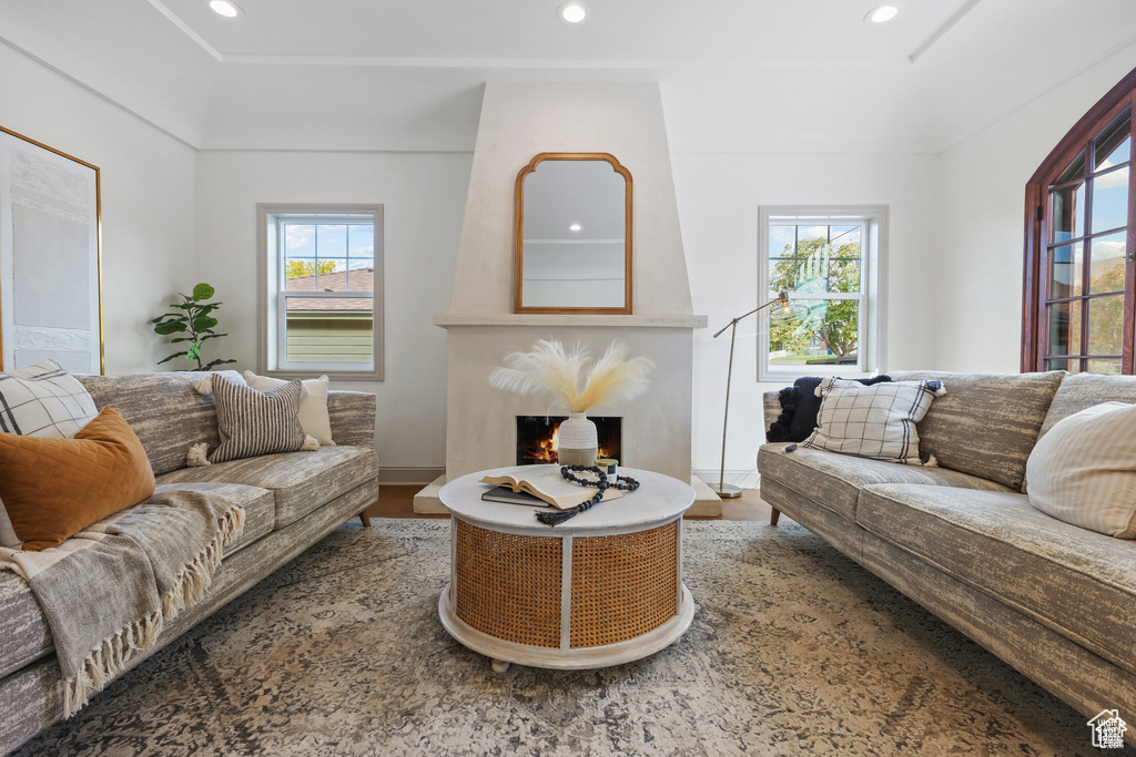 Living room featuring wood finished floors, recessed lighting, baseboards, and a warm lit fireplace