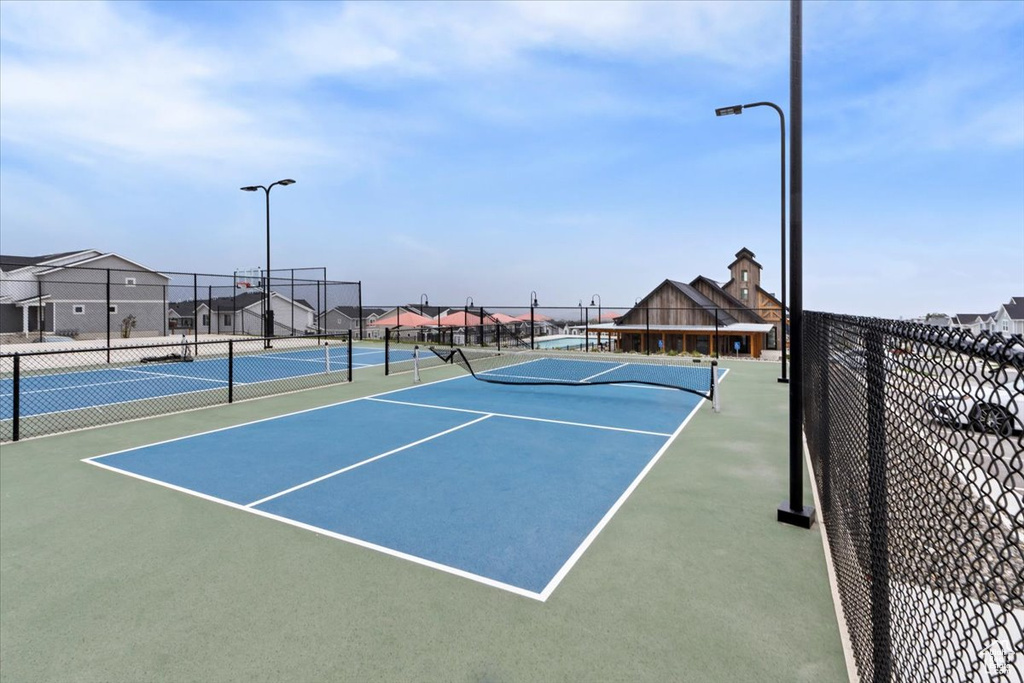 View of tennis court featuring fence