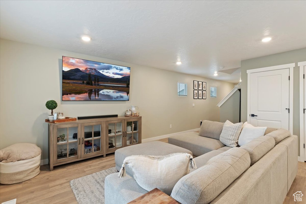 Living room featuring light wood-style flooring, baseboards, and recessed lighting