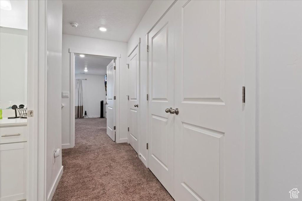 Hallway featuring carpet floors and baseboards