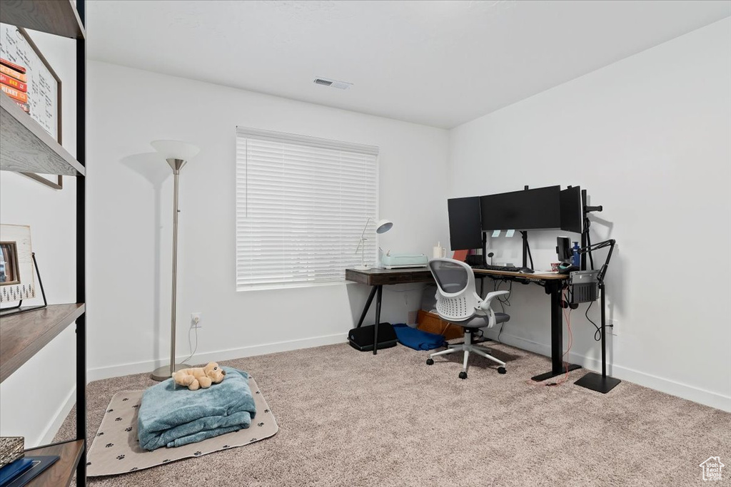 Carpeted office space featuring baseboards