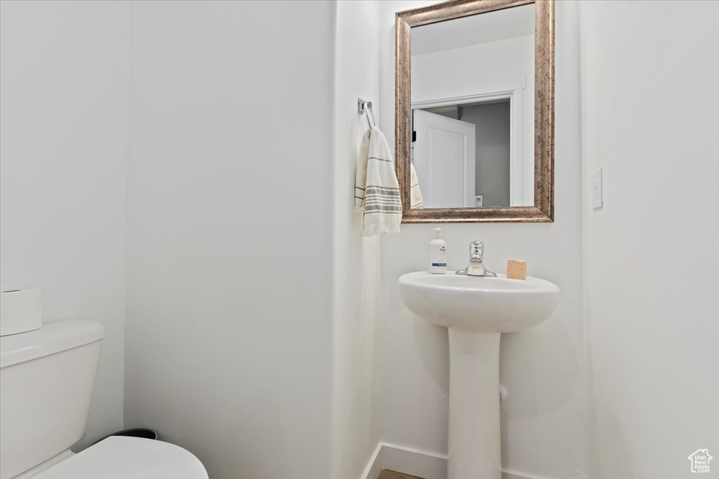 Half bathroom featuring toilet and baseboards