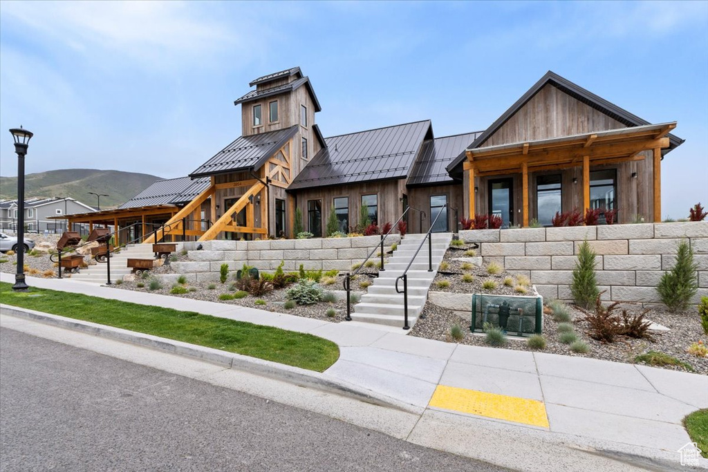 View of front of house featuring stairs, a standing seam roof, metal roof, board and batten siding, and a mountain view