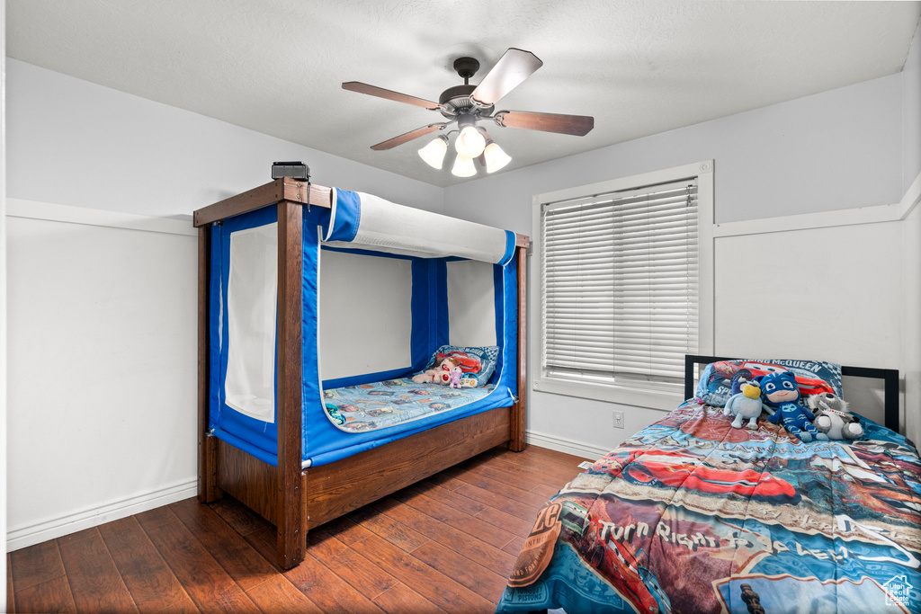 Bedroom featuring baseboards, hardwood / wood-style floors, and a ceiling fan