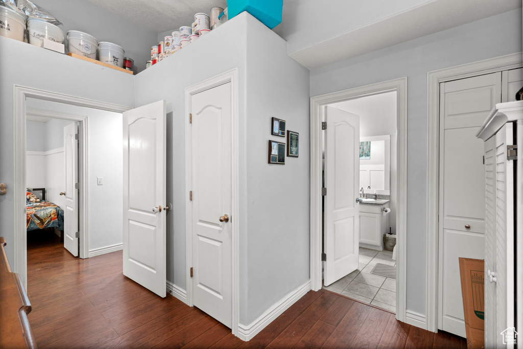 Corridor featuring dark wood-type flooring and baseboards