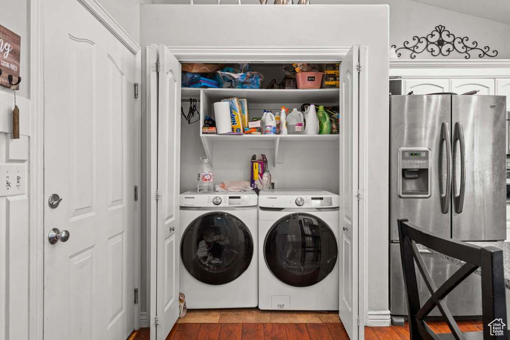 Laundry area with washer and dryer and wood finished floors