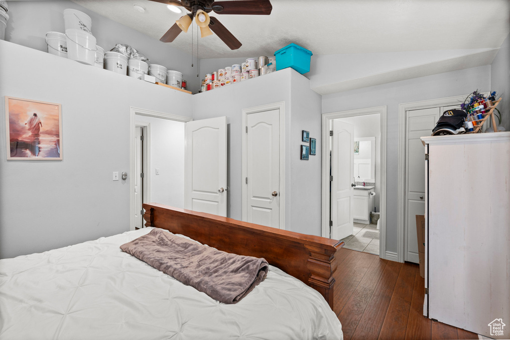 Bedroom featuring vaulted ceiling, wood-type flooring, a ceiling fan, and ensuite bathroom