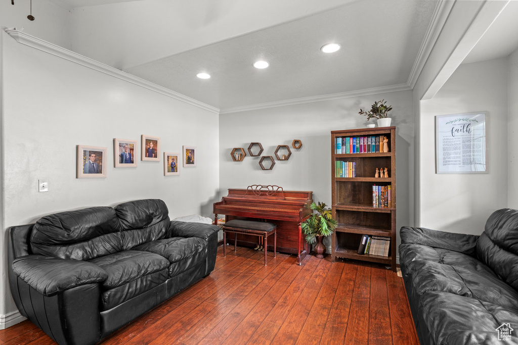 Living area featuring dark wood finished floors, ornamental molding, and recessed lighting