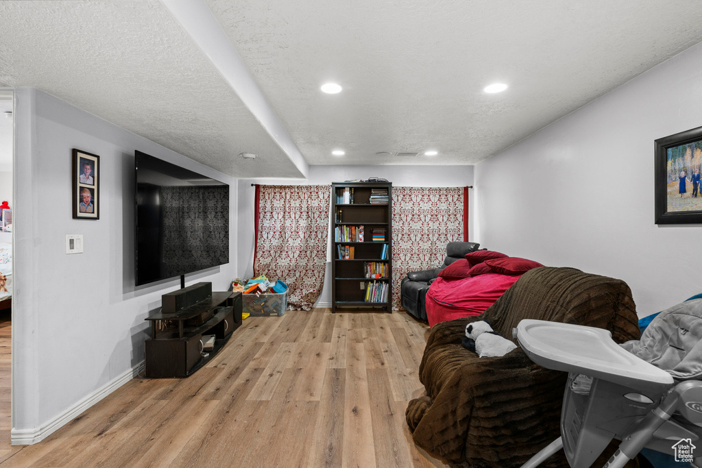 Living area with light wood-style flooring, recessed lighting, and baseboards