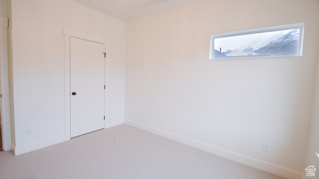 Unfurnished bedroom with light carpet, baseboards, and a closet