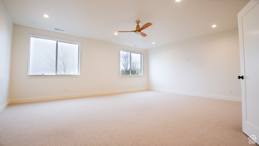 Empty room featuring light carpet, recessed lighting, a ceiling fan, and baseboards