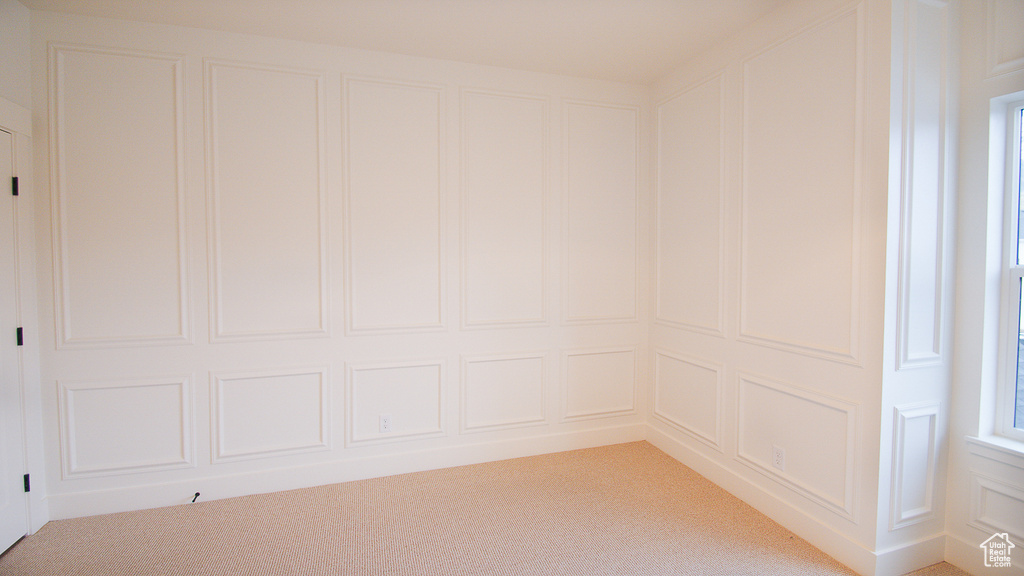 Spare room with a decorative wall and light colored carpet