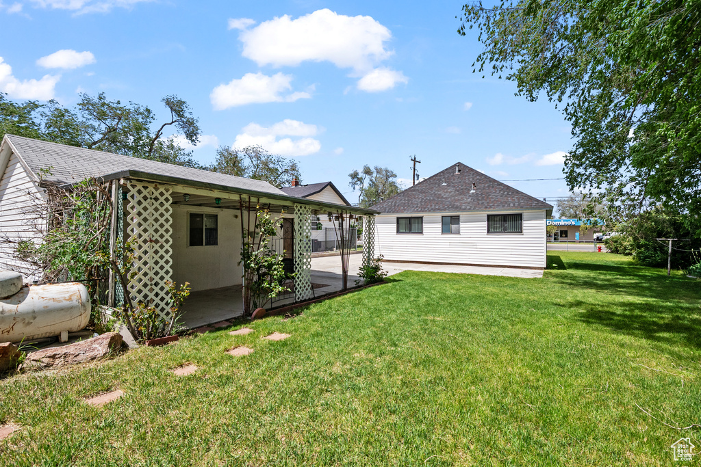 Rear view of house with a patio area and a yard