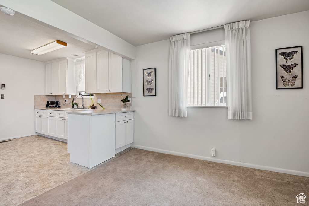 Kitchen featuring white cabinets, baseboards, and light countertops