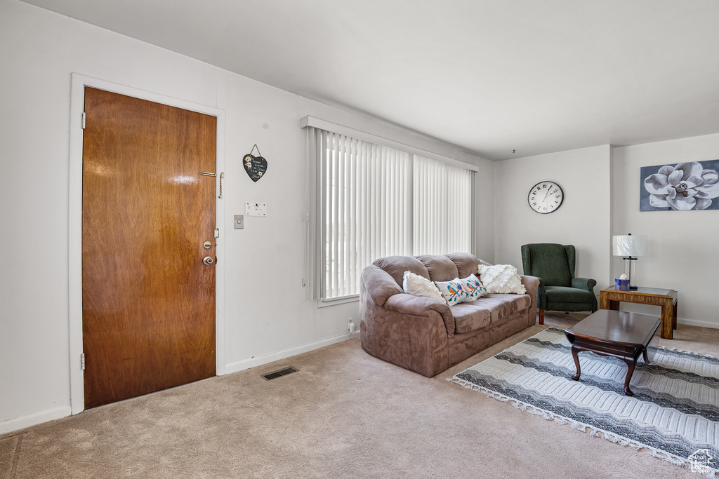 Carpeted living area featuring baseboards