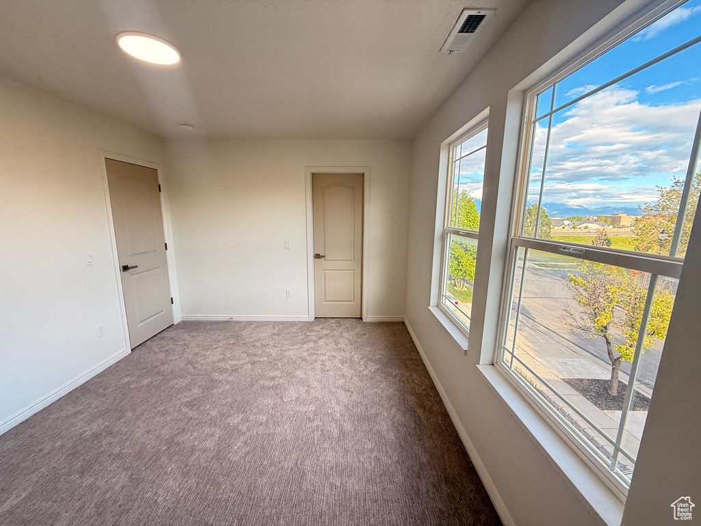 Carpeted spare room with baseboards