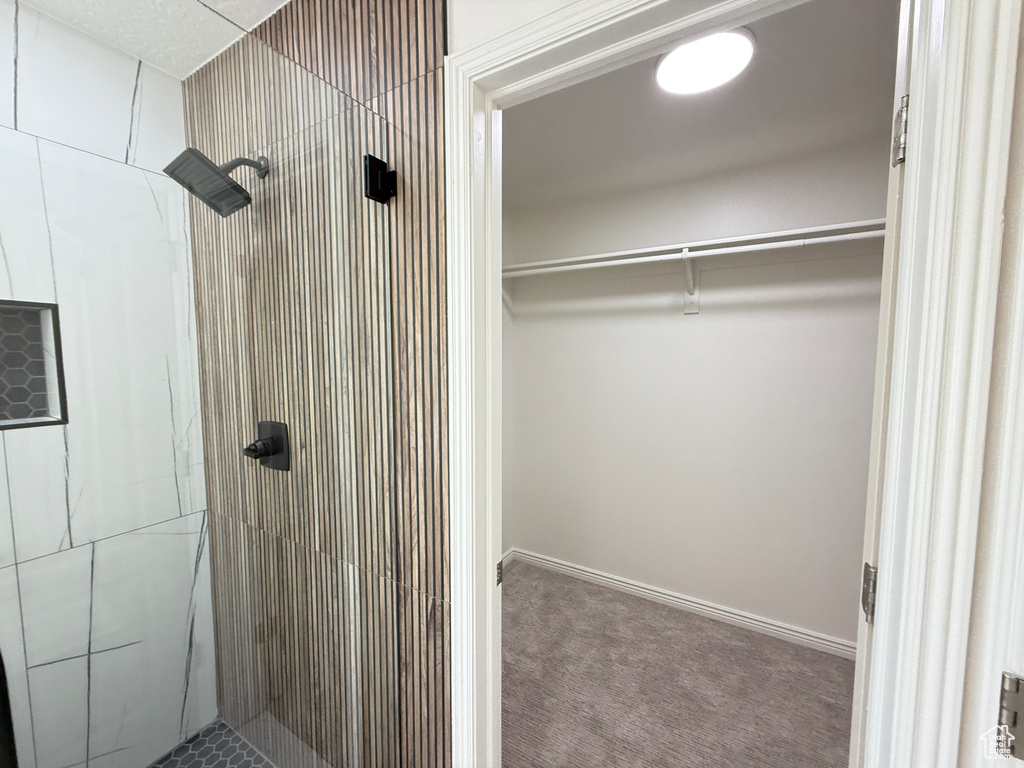 Bathroom with a stall shower and a spacious closet