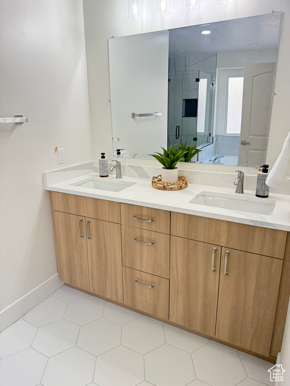 Bathroom featuring double vanity, a shower stall, baseboards, and a bath