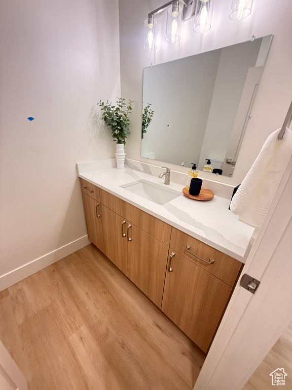 Bathroom with wood finished floors, baseboards, and vanity