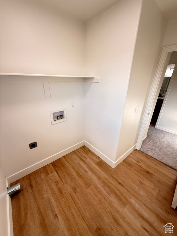 Clothes washing area featuring hookup for a washing machine, baseboards, electric dryer hookup, and wood finished floors