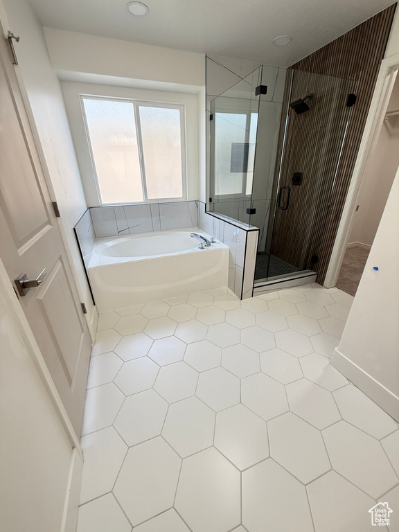 Full bath with tile patterned flooring, a bath, and a shower stall
