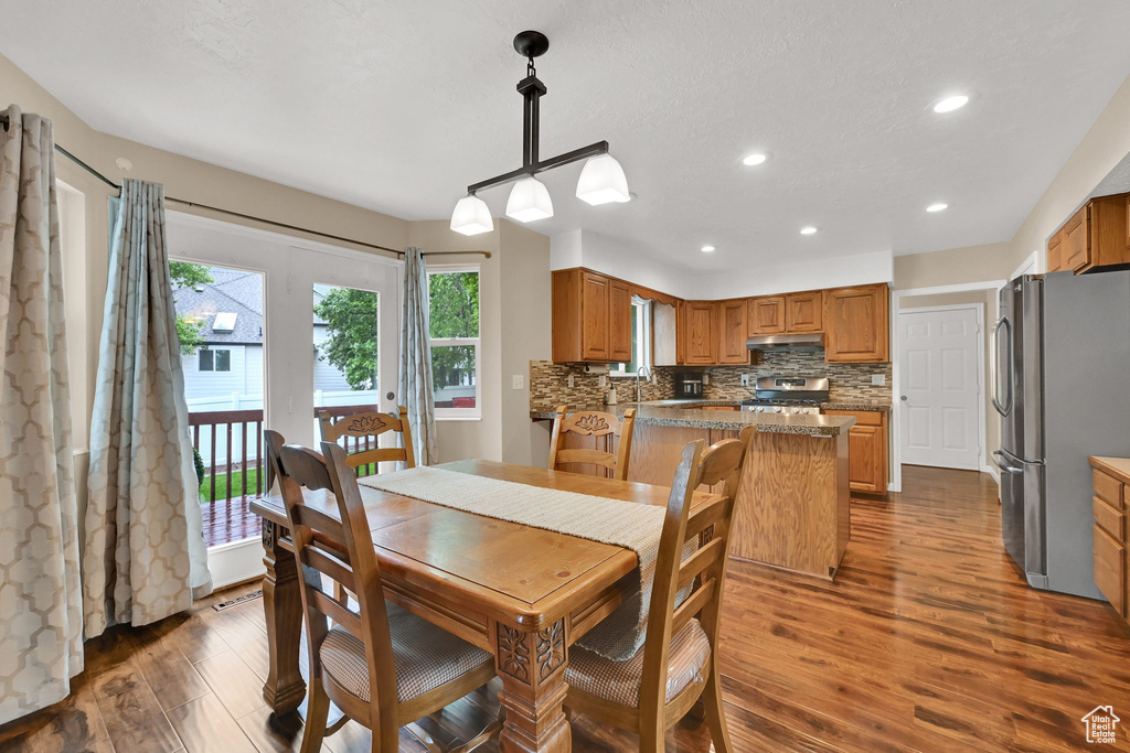 Dining room with dark wood-style floors and recessed lighting