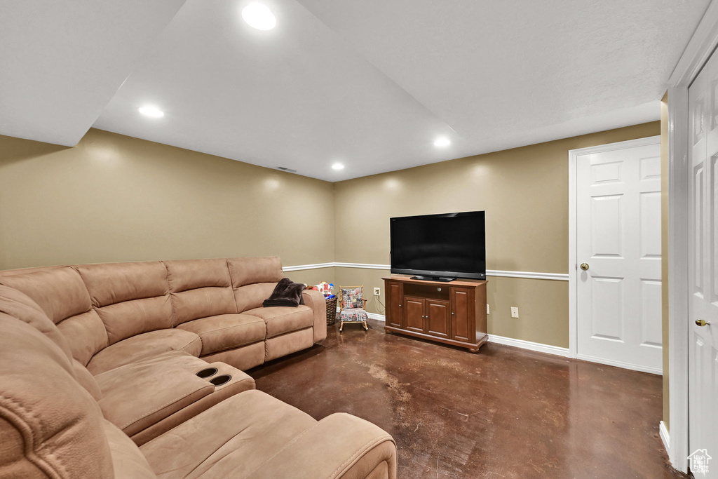 Living area with concrete flooring, recessed lighting, and baseboards