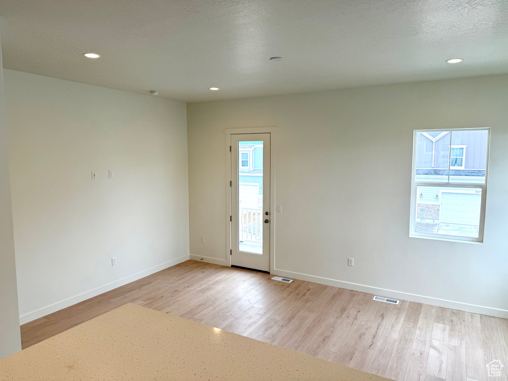 Unfurnished room featuring light wood-style floors, baseboards, and recessed lighting