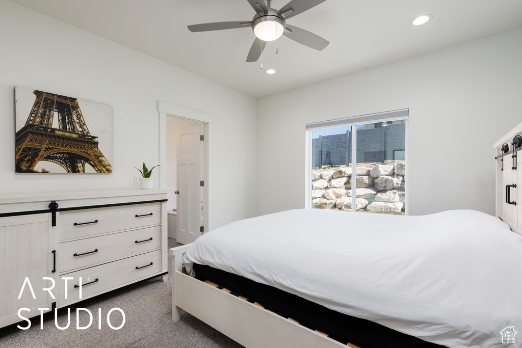 Bedroom with a barn door, recessed lighting, dark carpet, and a ceiling fan