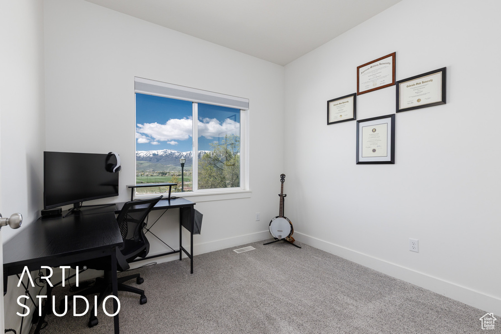 Carpeted home office featuring baseboards