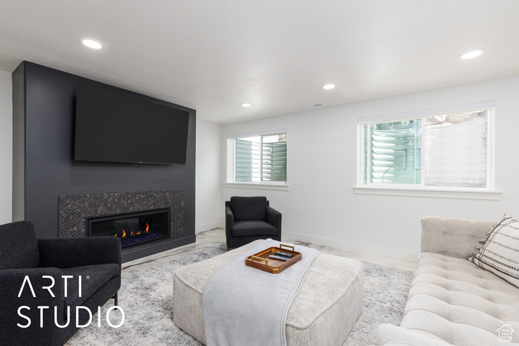 Living room with recessed lighting, a glass covered fireplace, and baseboards