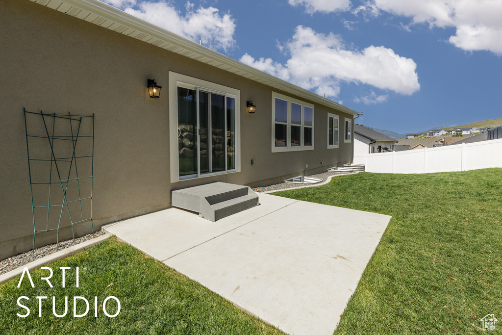 Rear view of house with stucco siding and a patio area