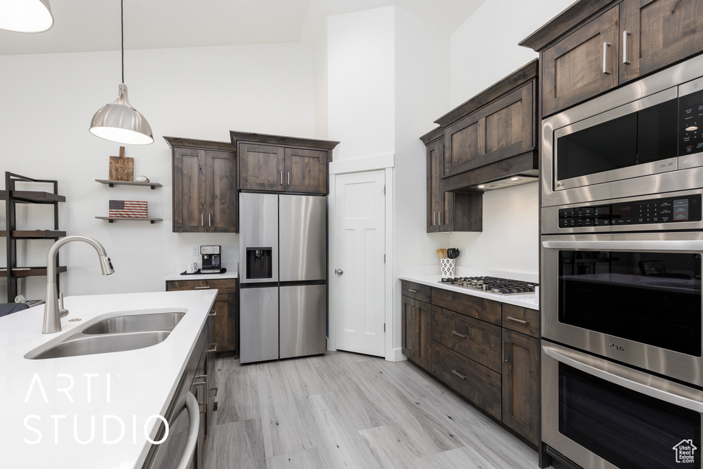 Kitchen with stainless steel appliances, a sink, and dark brown cabinetry