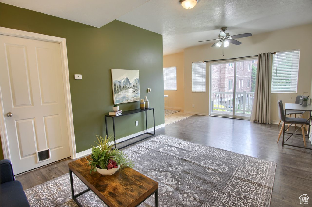 Living room featuring a ceiling fan, wood finished floors, and baseboards