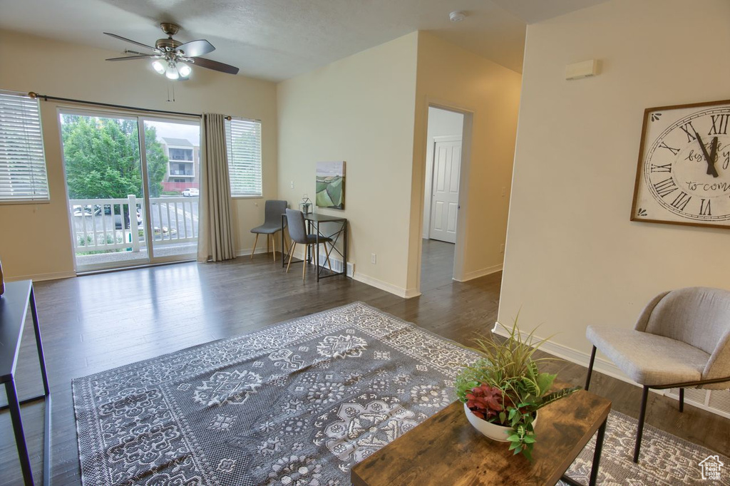 Living area with ceiling fan, wood finished floors, and baseboards