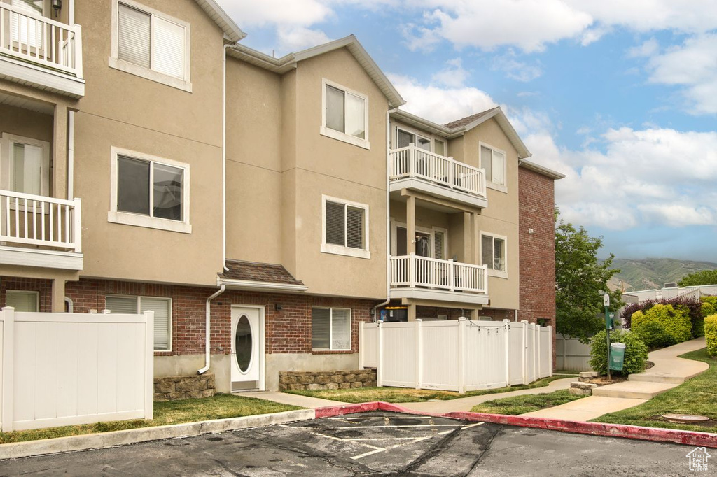 View of property featuring fence and uncovered parking