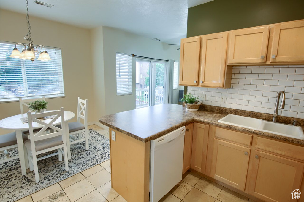 Kitchen with dishwasher, a sink, tasteful backsplash, light brown cabinets, and a peninsula