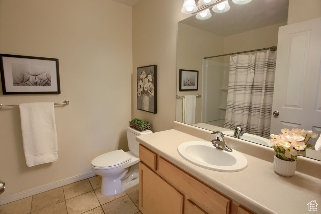Bathroom with tile patterned floors, toilet, baseboards, vanity, and a shower with curtain