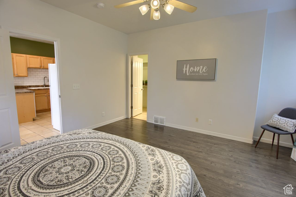 Bedroom featuring light wood finished floors, connected bathroom, and baseboards