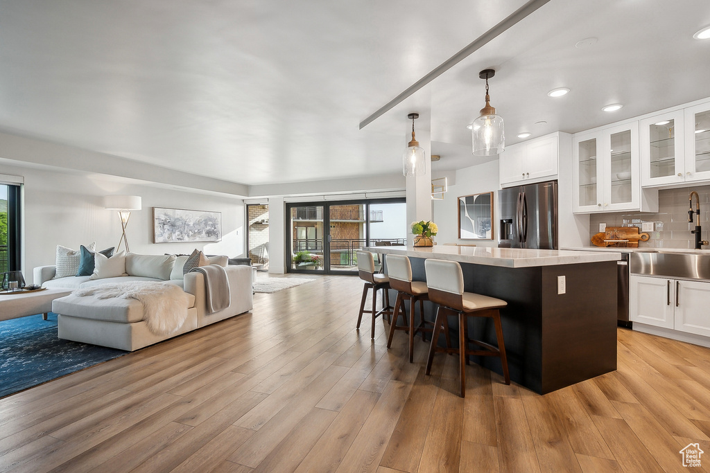 Kitchen with stainless steel fridge, a sink, healthy amount of natural light, open floor plan, and recessed lighting