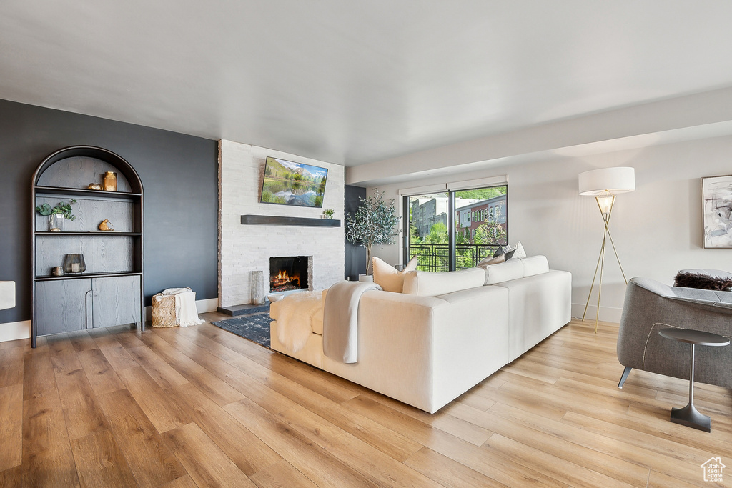 Living area with light wood-style flooring and a stone fireplace