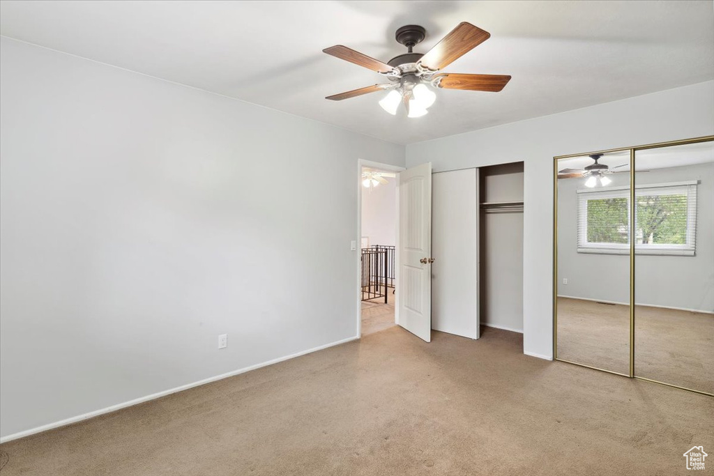 Unfurnished bedroom featuring two closets, carpet flooring, baseboards, and a ceiling fan
