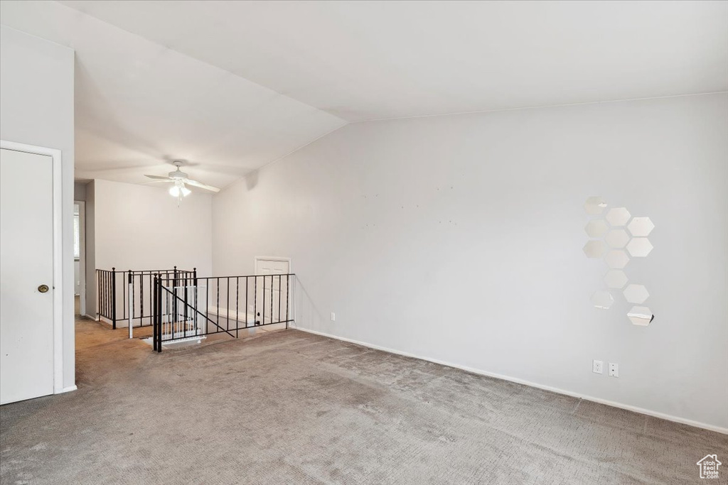 Unfurnished room with a ceiling fan, carpet, and vaulted ceiling