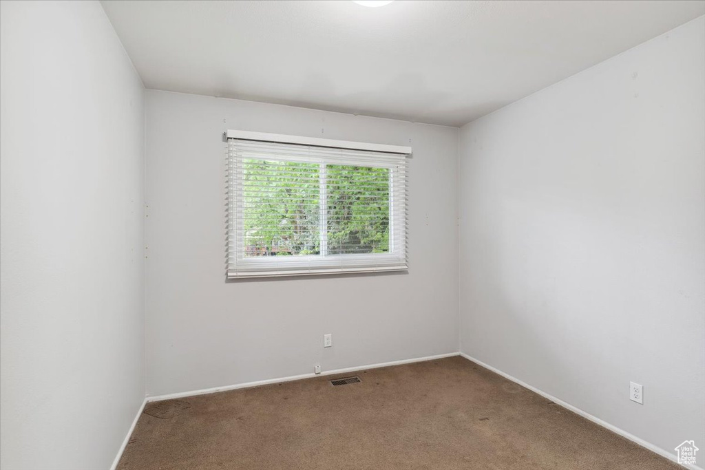 Carpeted spare room with baseboards