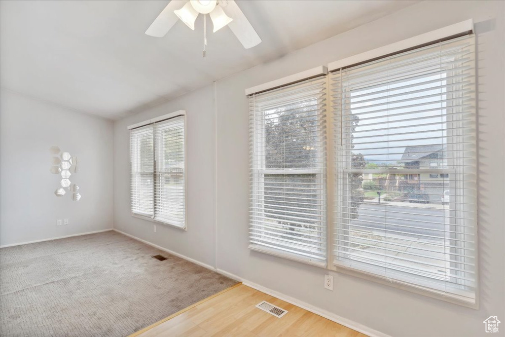 Spare room with a ceiling fan, baseboards, and wood finished floors