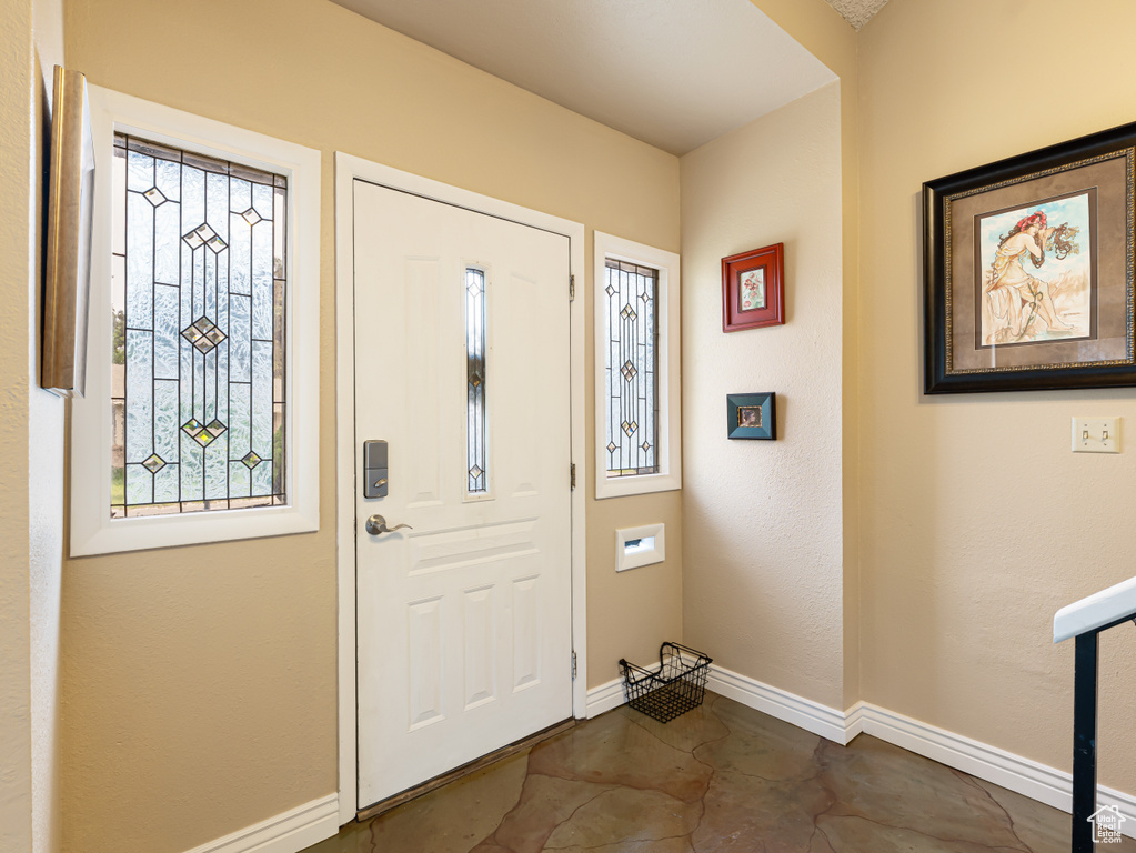 Entryway featuring baseboards and concrete flooring