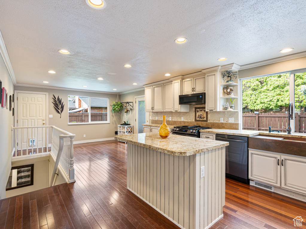 Kitchen with black microwave, dishwashing machine, a sink, stainless steel range with gas cooktop, and crown molding